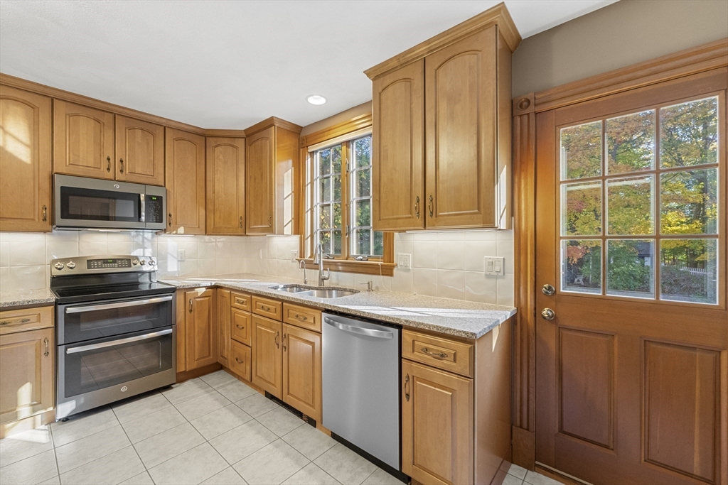 3 Laurel Street Woburn, MA 01801 - Photo 16 of 40 a kitchen with stainless steel appliances granite countertop a stove a sink and a microwave