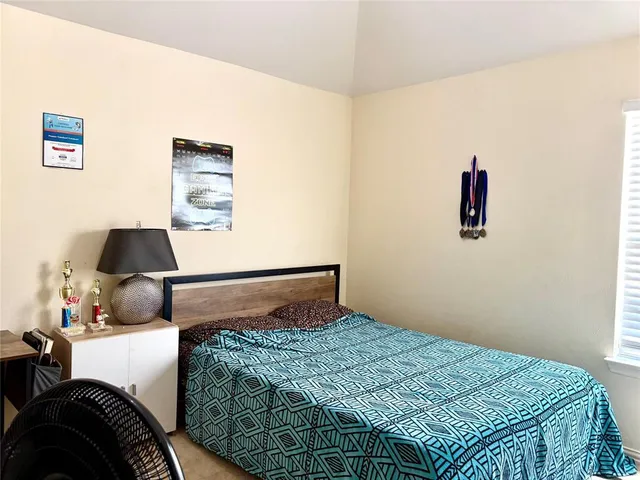 a bedroom with a bed and a lamp on the dresser