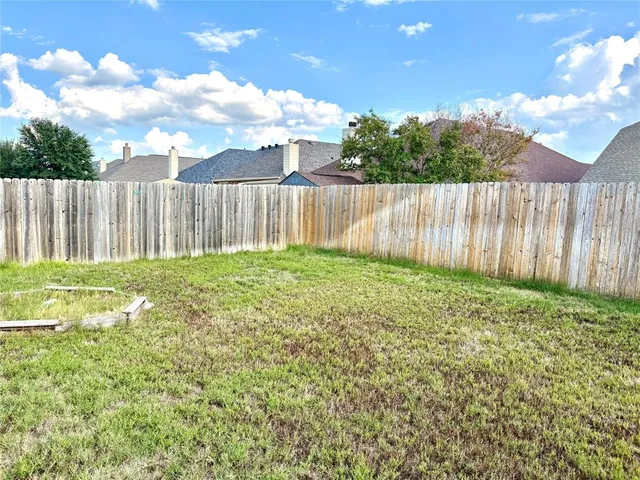 a view of backyard with wooden fence