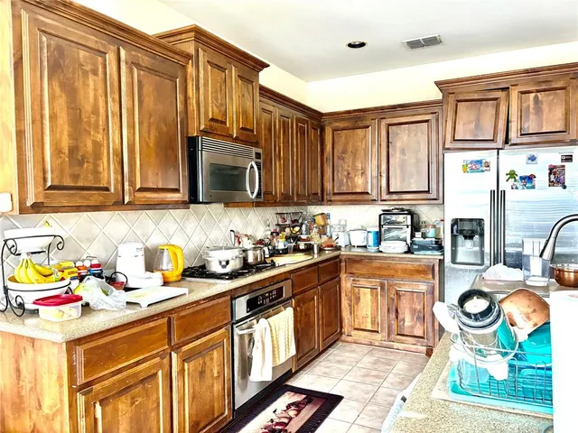 a kitchen with stainless steel appliances granite countertop a stove a sink and a microwave