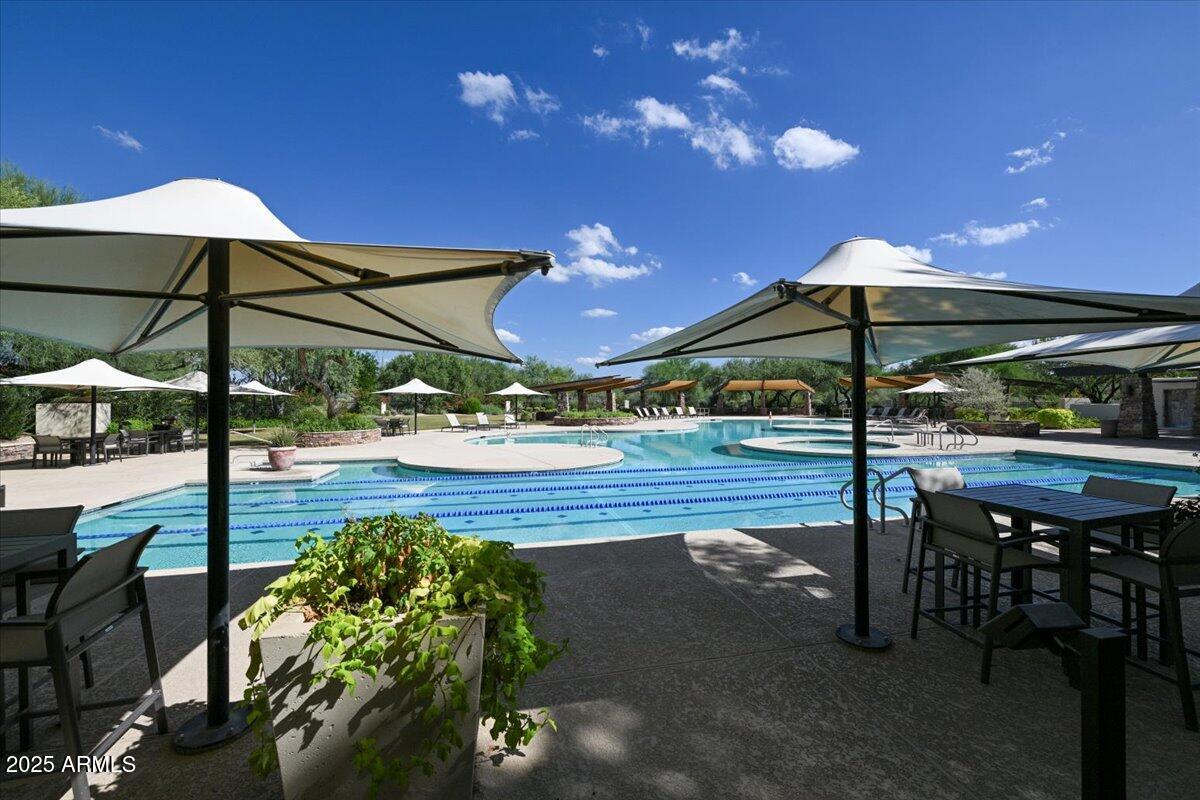 3935 East Rough Rider Road, Unit 1191 Phoenix, AZ 85050 - Photo 24 of 32 a view of a patio with a table and chairs under an umbrella