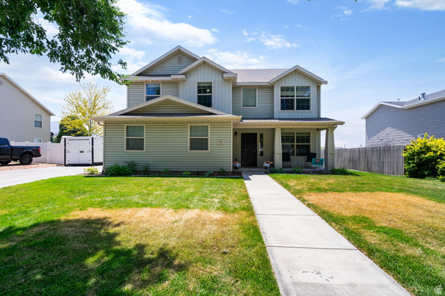 1393 West 150 North Springville, UT 84663 - Photo 1 of 31 Two-story residence featuring light-colored siding, a covered porch, and a concrete walkway