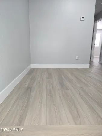 a view of an empty room with wooden floor