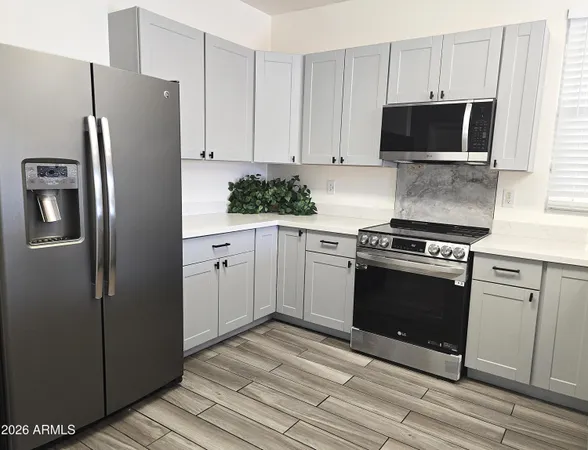 a kitchen with stainless steel appliances white cabinets a refrigerator and a stove