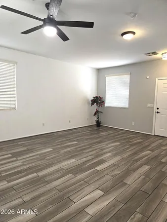 an empty room with wooden floor and windows