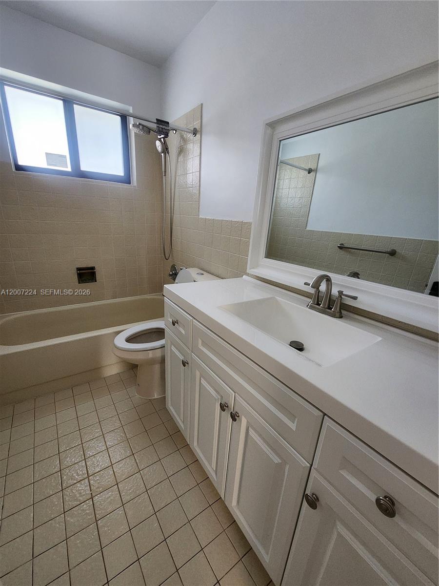 11025 Southwest 138th Court, Unit 11025 Miami, FL 33186 - Photo 15 of 21 a bathroom with a sink a toilet and mirror
