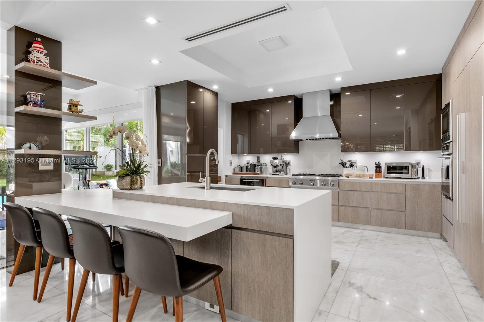 1666 Tigertail Avenue Miami, FL 33133 - Photo 11 of 41 a kitchen with stainless steel appliances kitchen island granite countertop a sink and cabinets