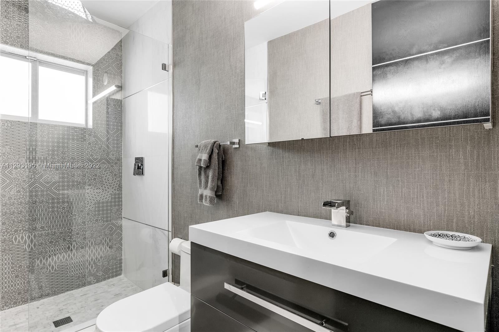 1666 Tigertail Avenue Miami, FL 33133 - Photo 26 of 41 a bathroom with a sink a toilet and shower