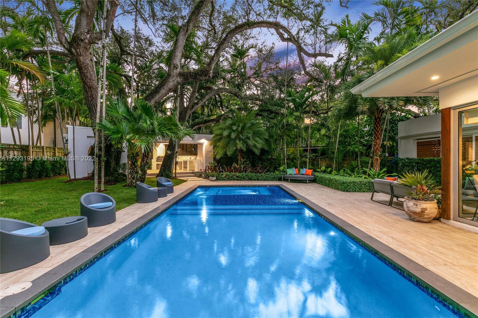 1666 Tigertail Avenue Miami, FL 33133 - Photo 3 of 41 a view of a swimming pool and lounge chairs in the patio