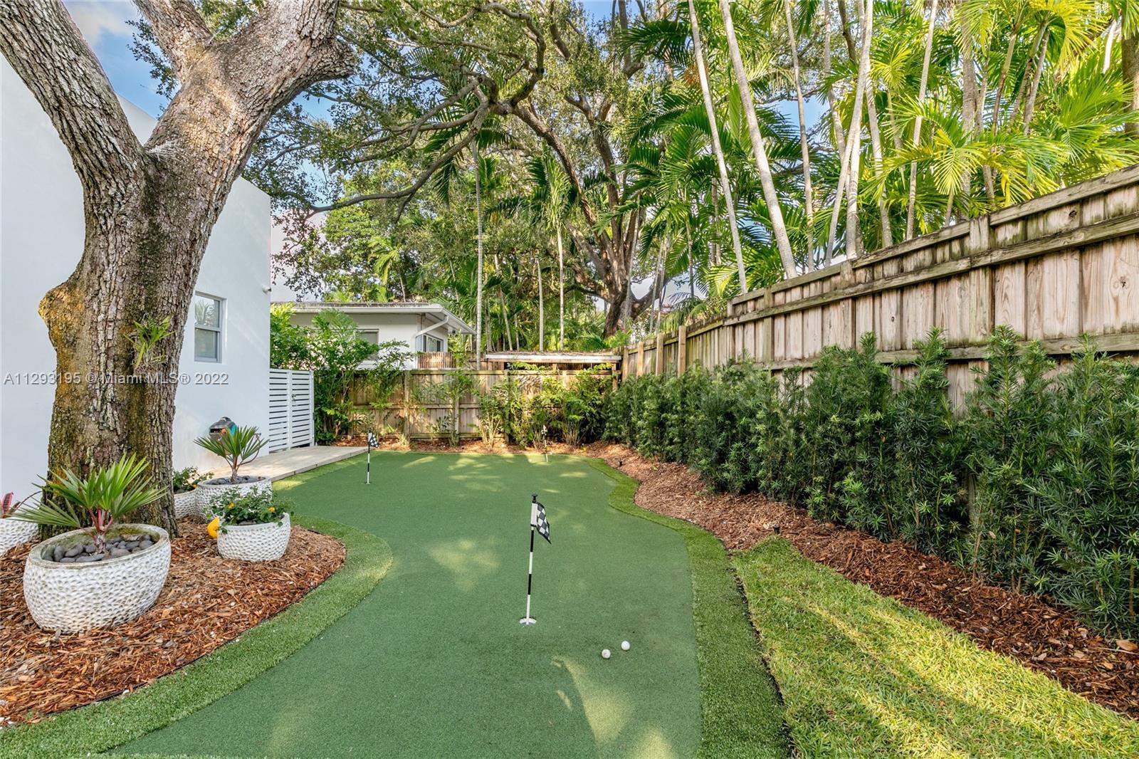 1666 Tigertail Avenue Miami, FL 33133 - Photo 35 of 41 a view of a backyard with potted plants and large trees