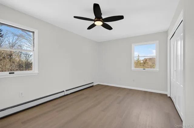 an empty room with a window and a fan