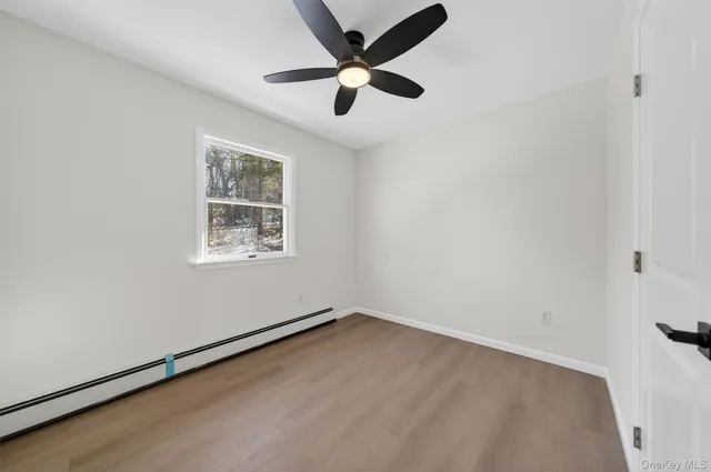 an empty room with a ceiling fan and window