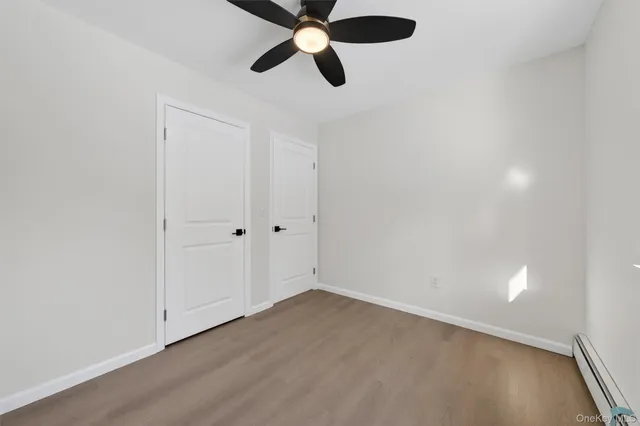 an empty room with closet and ceiling fan