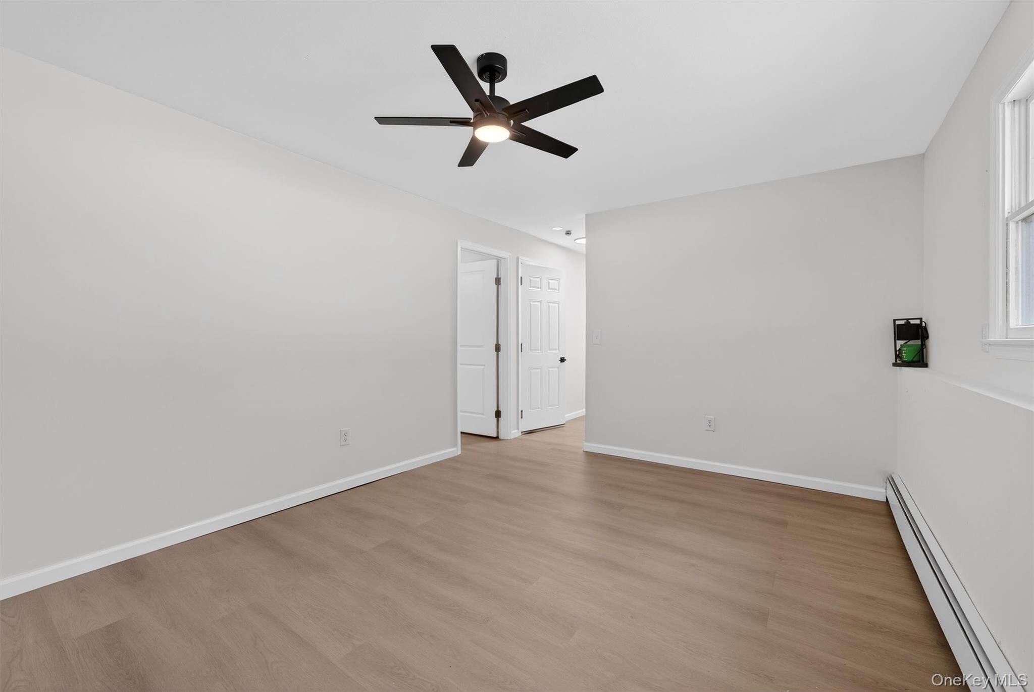 7 Edenville Road Warwick, NY 10990 - Photo 29 of 38 Empty room with a baseboard radiator, light wood-style floors, and ceiling fan