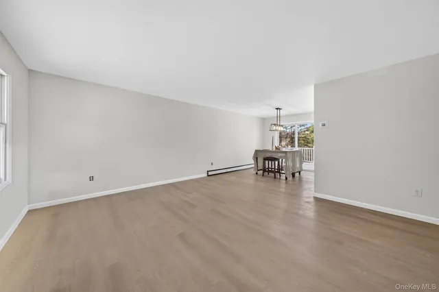 a large white kitchen with a sink dishwasher and a stove with wooden floor
