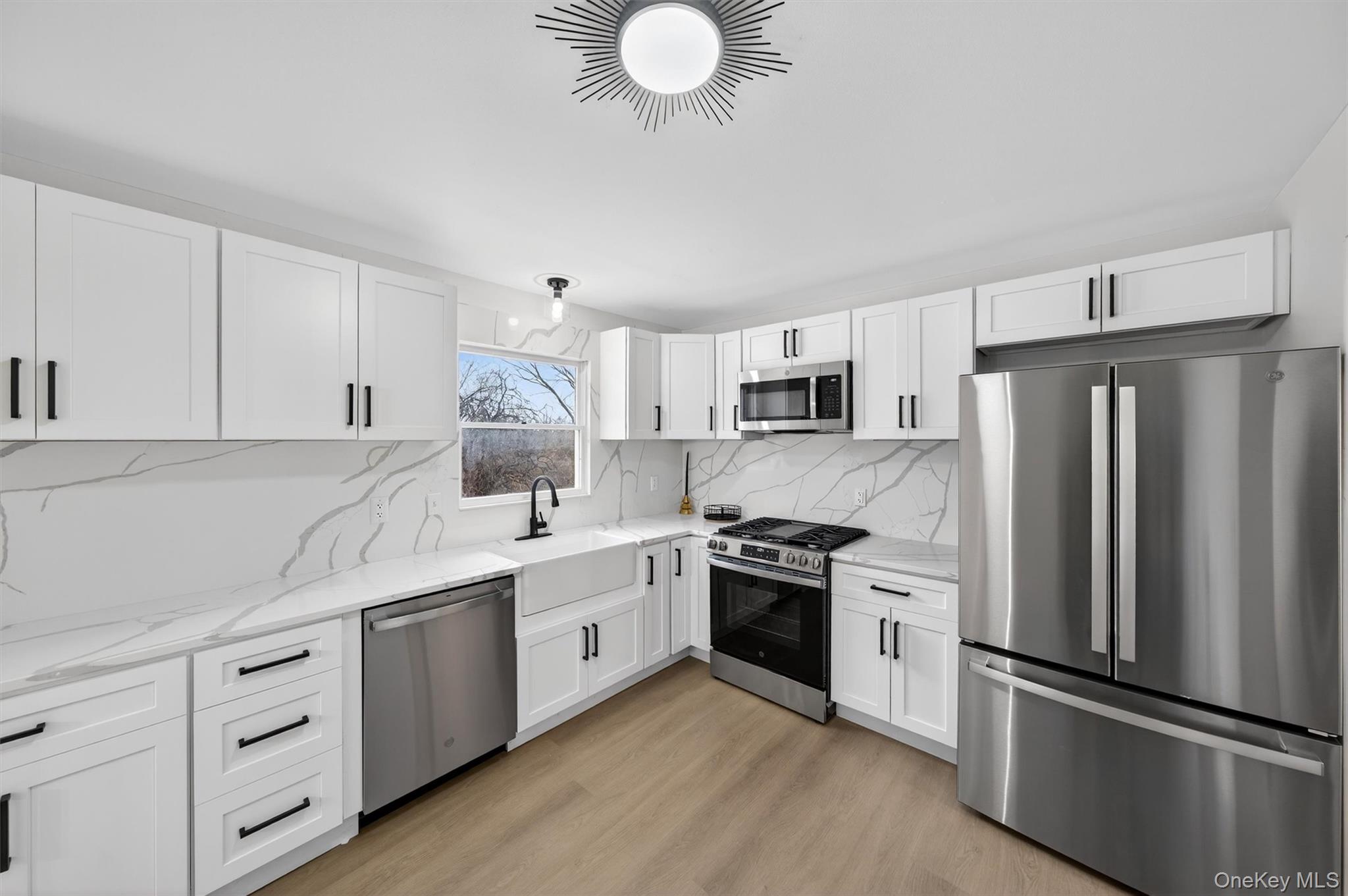 7 Edenville Road Warwick, NY 10990 - Photo 9 of 38 Kitchen with appliances with stainless steel finishes, white cabinetry, light stone countertops, and tasteful backsplash
