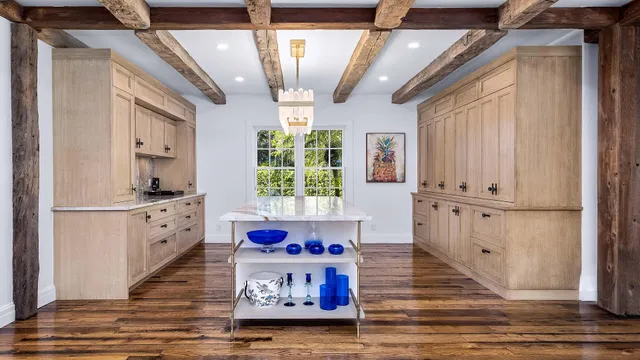 a very nice looking kitchen with white cabinets and wooden floor