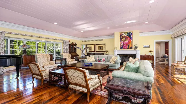 a living room with fireplace furniture and a large window
