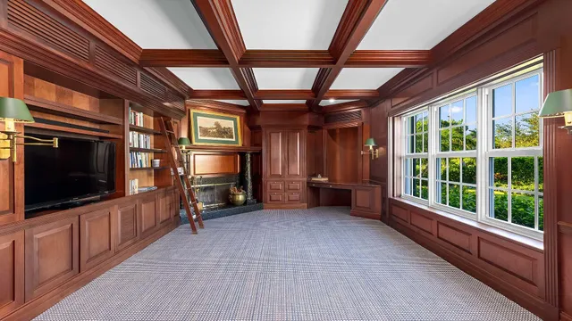 a view of an empty room with a fireplace and a window