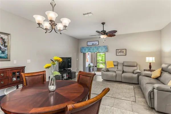 a living room with fireplace chandelier and a wooden floor