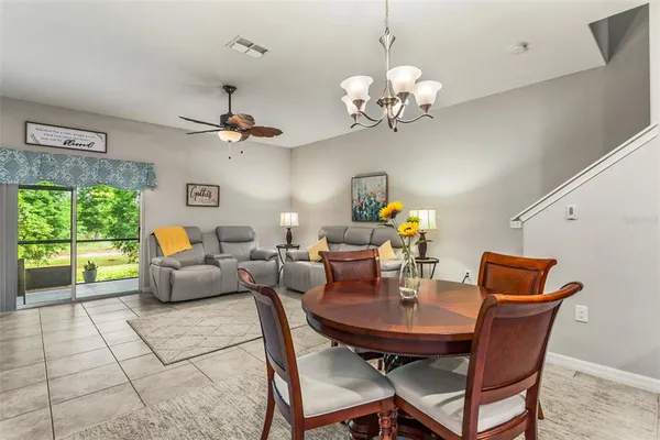 a dining room with furniture a large window and a chandelier