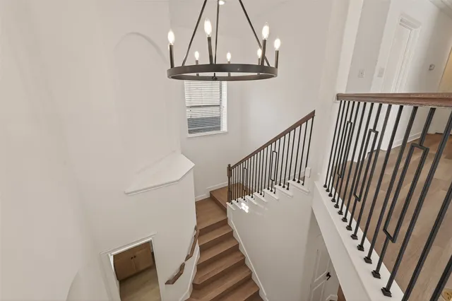 a view of staircase with railing and white walls