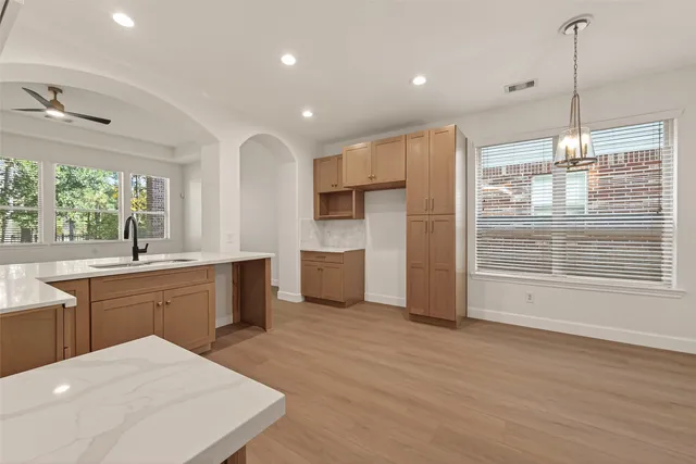 a kitchen with stainless steel appliances a kitchen island hardwood floor sink stove and wooden floor