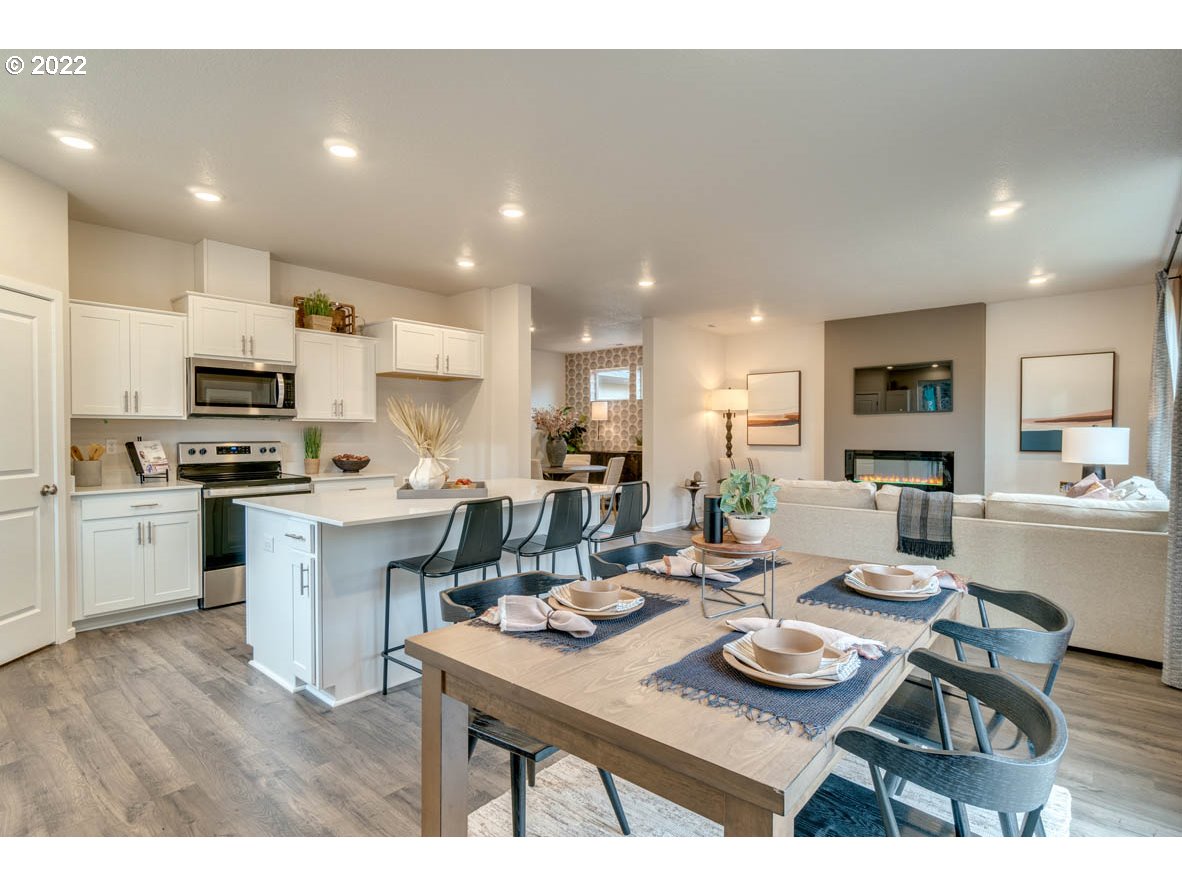 3122 Southeast 34th Way Gresham, OR 97080 - Photo 9 of 26 a open dining room with kitchen island wooden floor and stainless steel appliances