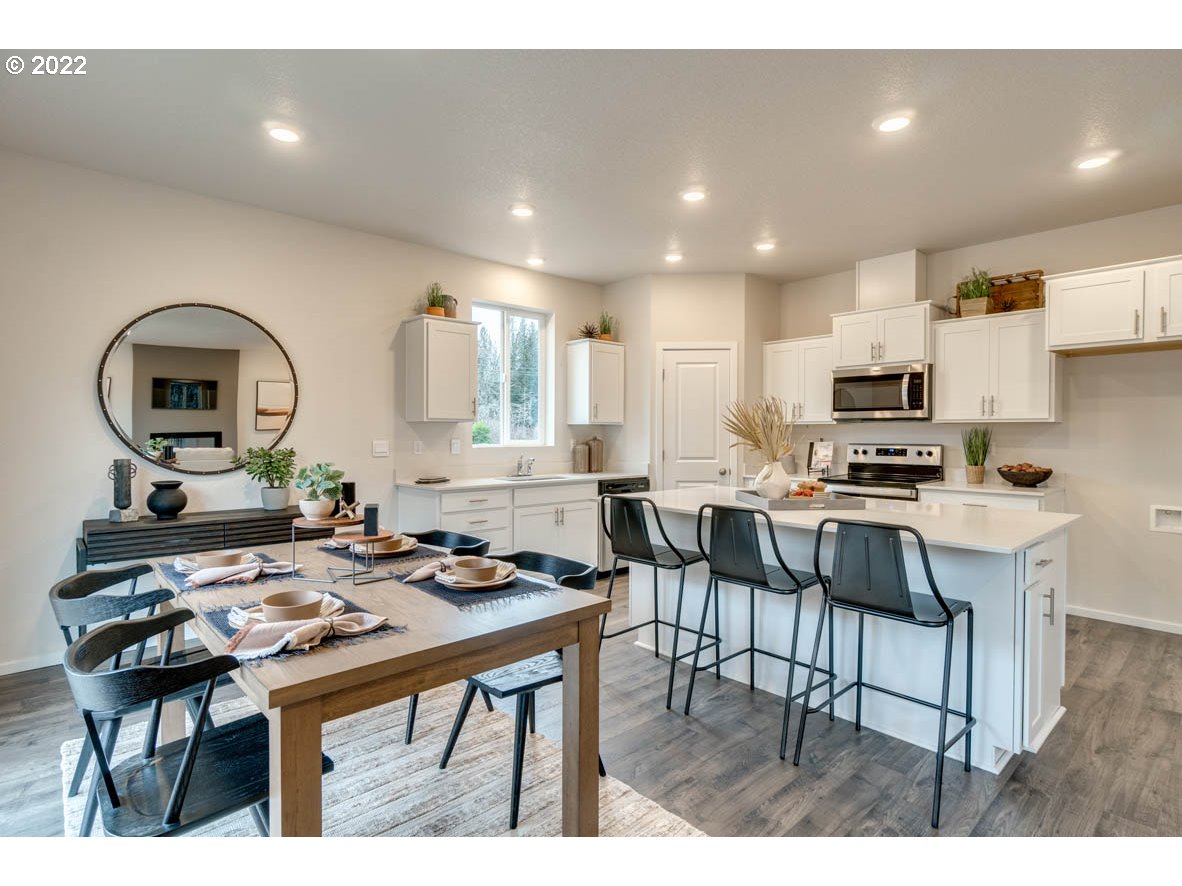 3122 Southeast 34th Way Gresham, OR 97080 - Photo 10 of 26 a kitchen with a dining table chairs and a refrigerator