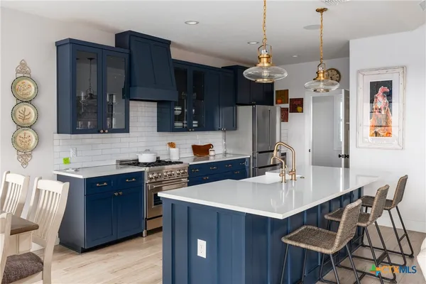 a kitchen with stainless steel appliances a sink stove and refrigerator