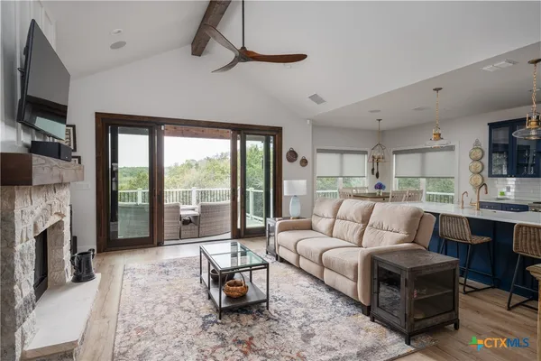 a living room with furniture a flat screen tv and a fireplace