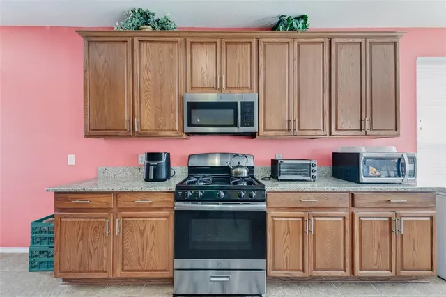 a kitchen with granite countertop a stove top oven cabinetry and granite counter tops