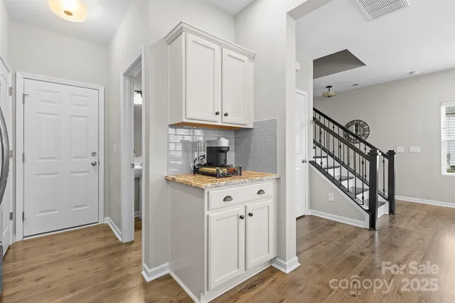 a view of hallway with wooden floor and stairs