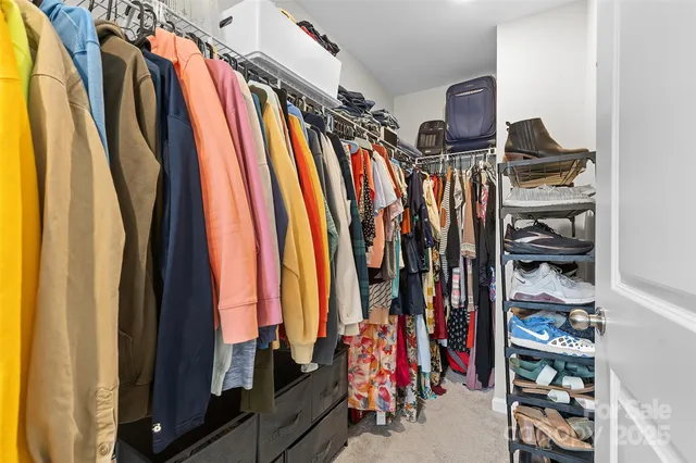 a view of walk in closet with clothes and shoes