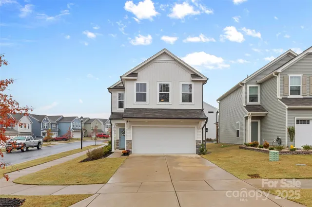 a view of a white house with a swimming pool and a yard