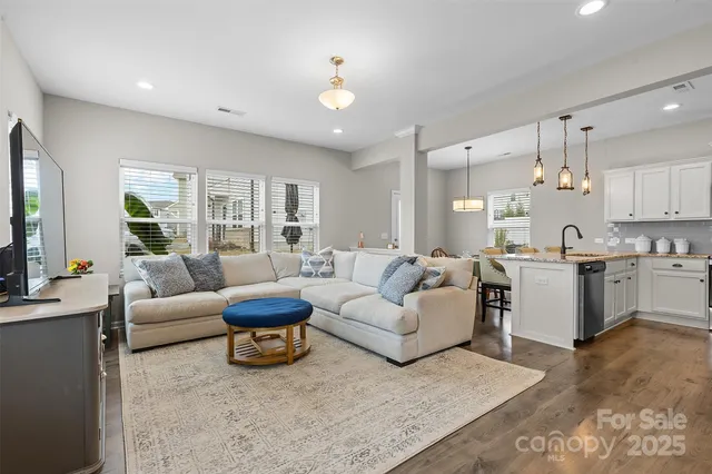 a living room with furniture white walls and kitchen view