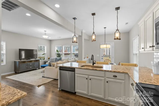 a open kitchen with stainless steel appliances granite countertop a sink a stove and a wooden floors