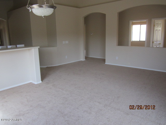 941 West Carter Road Phoenix, AZ 85041 - Photo 3 of 10 an empty room with a mirror and chandelier