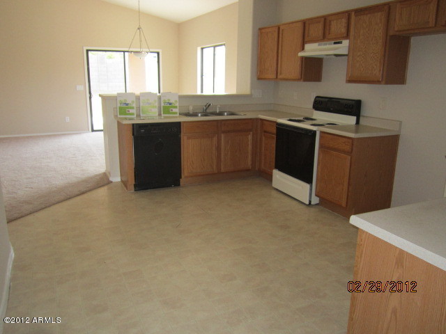 941 West Carter Road Phoenix, AZ 85041 - Photo 4 of 10 a kitchen with stainless steel appliances granite countertop a stove a sink and a microwave