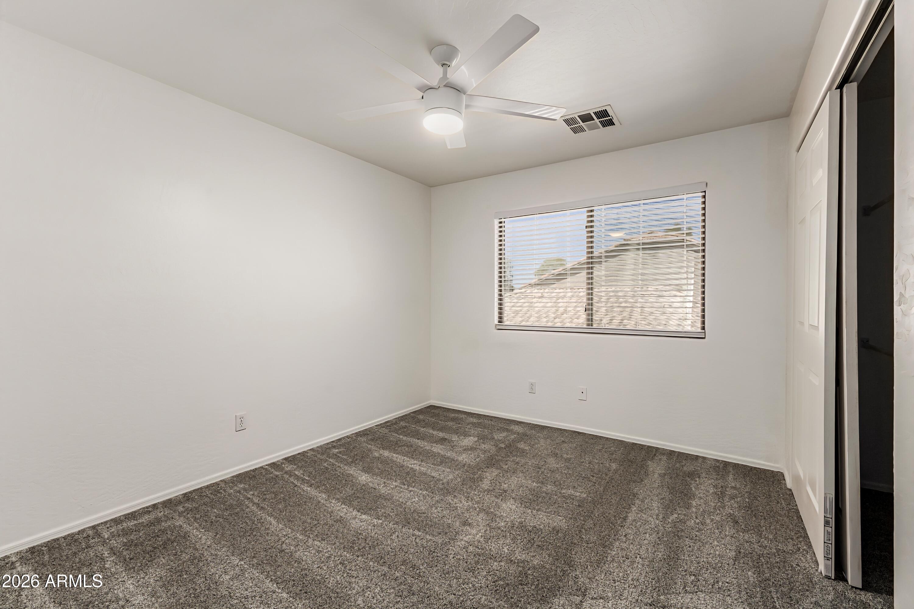 4208 South Sawmill Road Gilbert, AZ 85297 - Photo 28 of 46 an empty room with a chandelier fan and windows