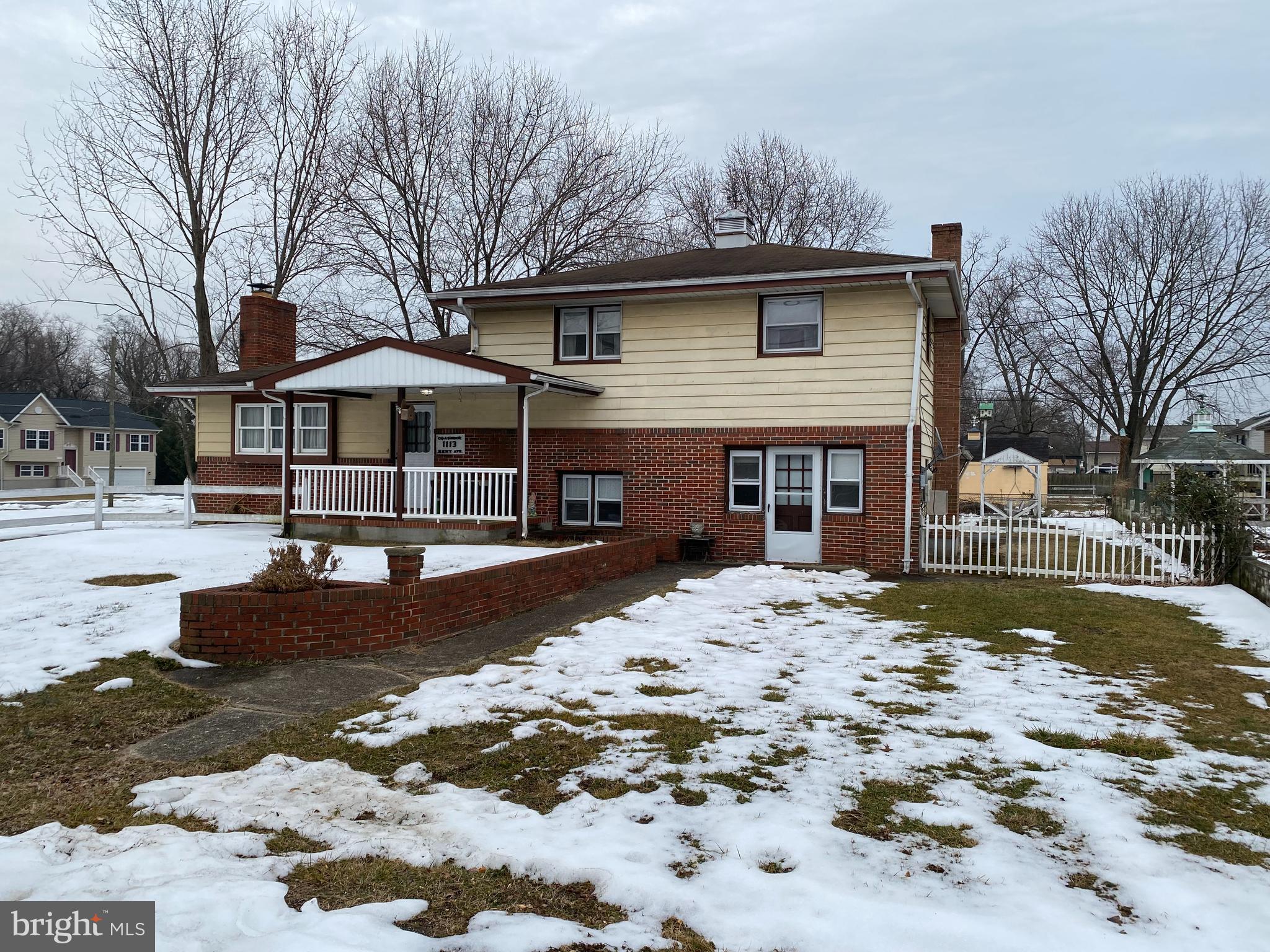 a front view of a house with a yard covered with snow