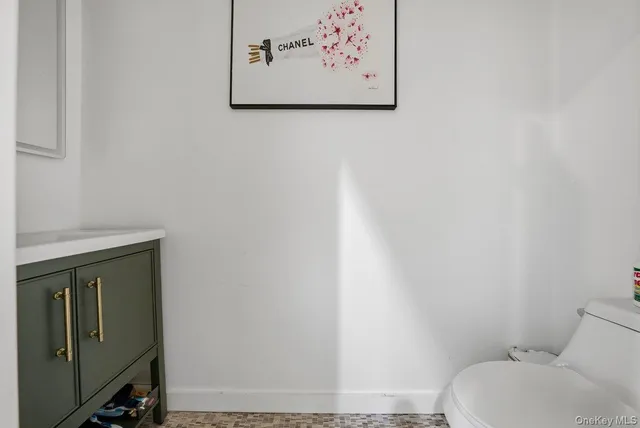a white toilet sitting next to a white wall