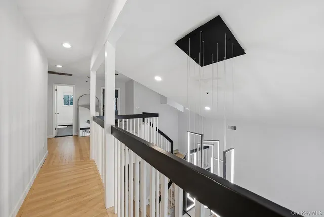 a view of a hallway with wooden floor and stairs