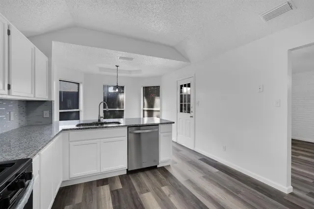a kitchen with granite countertop a sink and cabinets