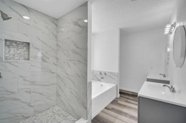 a bathroom with a tub sink and mirror