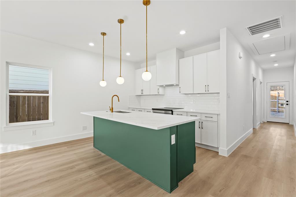 4827 Baldwin Street Dallas, TX 75210 - Photo 3 of 21 a kitchen with kitchen island a sink stainless steel appliances and cabinets
