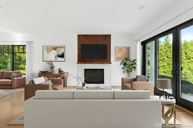a living room with furniture a large window and a flat screen tv