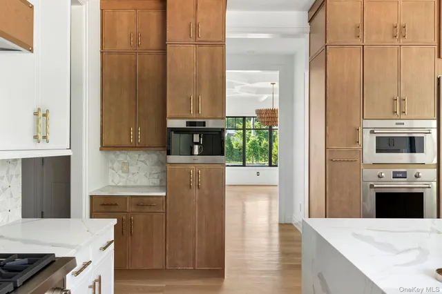 a kitchen with stainless steel appliances kitchen island granite countertop a refrigerator a stove and a sink with wooden floor