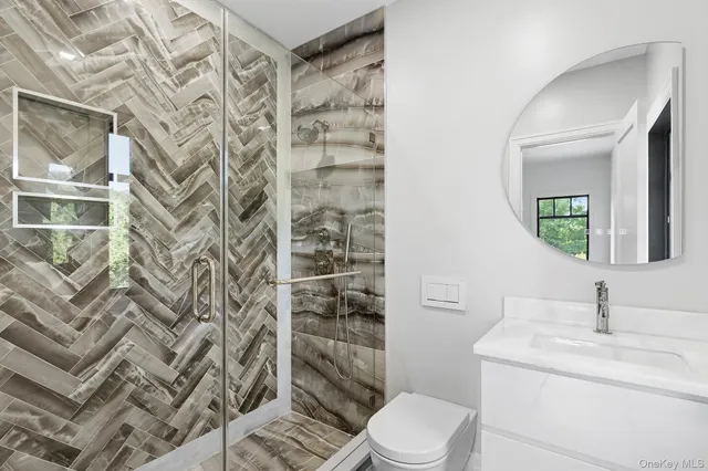 a bathroom with a sink a toilet and shower