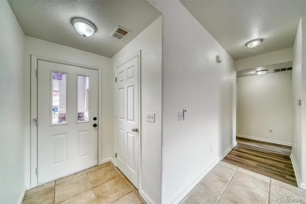 a view of a hallway with wooden floor and a bathroom